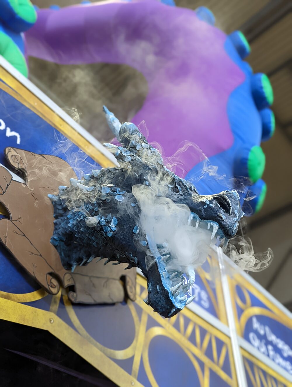 Tête de dragon sculptée soufflant de la fumée bleue